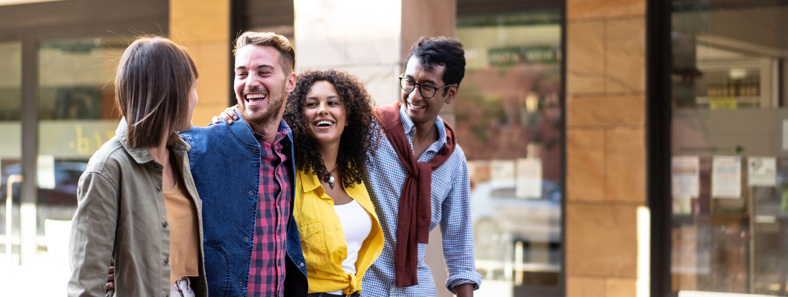 horizontal banner or header with multi cultural friends walking in city center happy guys and girls having fun around shopping town streets university students on travel vacations
